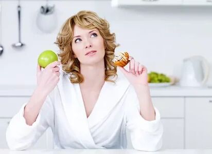 Dziewczyna wybiera między jabłkiem a ciasto