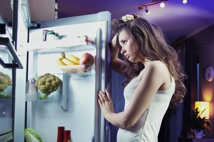 dziewczyna przy lodówce, przestrzegając swojej ulubionej diety